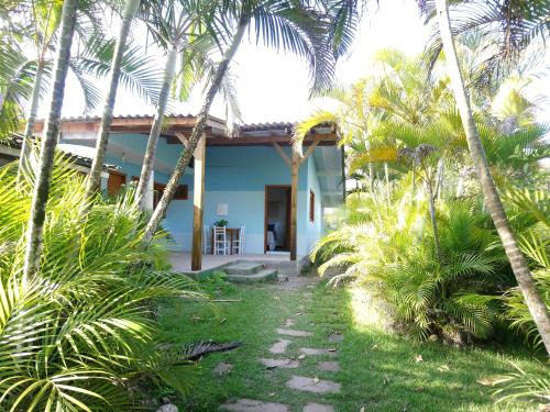 uma casa com palmeiras em frente em Pousada la Boheme Guarda do Embaú - SC em Guarda do Embaú