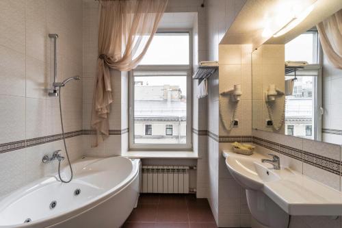 łazienka z wanną, umywalką i oknem w obiekcie Sapphire Hotel w Petersburgu