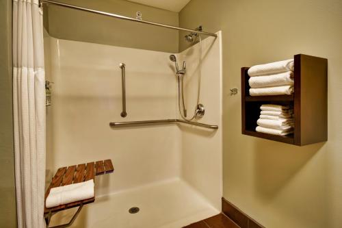 a bathroom with a shower and a tub with towels at Staybridge Suites Middleton/Madison-West by IHG in Middleton