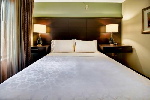 a bedroom with a large white bed with two lamps at Staybridge Suites Middleton/Madison-West by IHG in Middleton