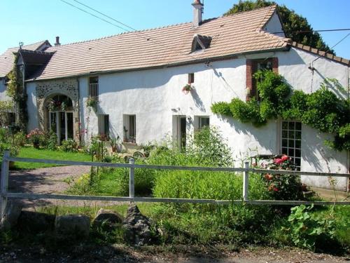 una casa bianca con una recinzione di fronte di Chambre d'hôtes Ermitage Saint Romble a Crézancy