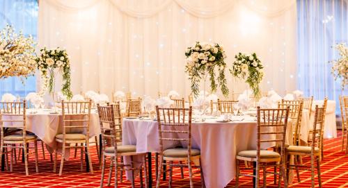 a wedding banquet room with tables and chairs with flowers at Britannia Country House Hotel & Spa in Manchester