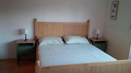 a bedroom with a wooden bed with two night stands at Bolla's apartament Plan de Corones Kronplatz in Valdaora