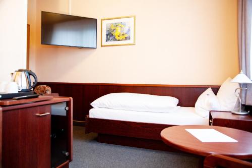 a hotel room with a bed and a table at Hotel Lonac in Duisburg