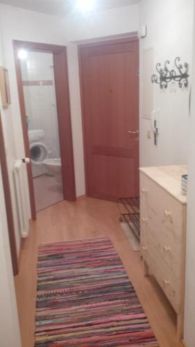 baño con puerta roja y lavamanos en Bolla's apartament Plan de Corones Kronplatz, en Valdaora