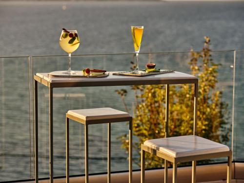 a table with two chairs and a wine glass on it at Ionian Hill Hotel in Argassi