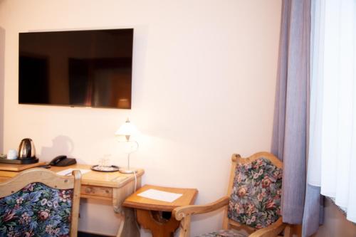 a room with a table and two chairs and a desk at Hotel Lonac in Duisburg