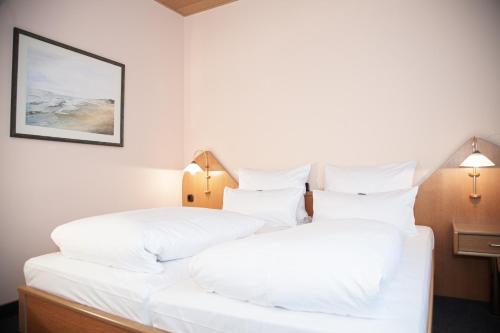 two beds in a hotel room with white pillows at Hotel Lonac in Duisburg