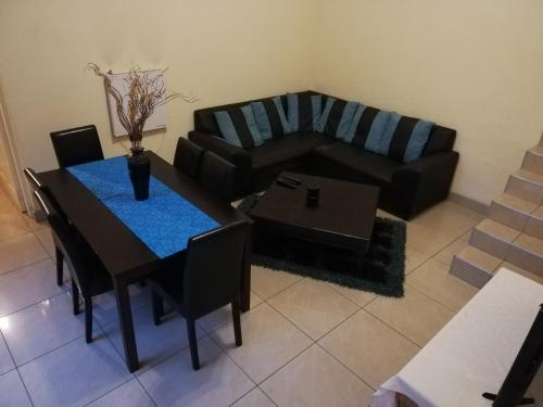 ein Wohnzimmer mit einem Tisch und einem Sofa in der Unterkunft Rocky Ridge Guest House SELF Catering - No alcohol allowed in Roodepoort