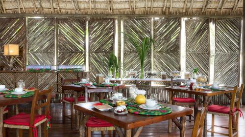 a restaurant with wooden tables and chairs and windows at Rancho Do Peixe in Prea