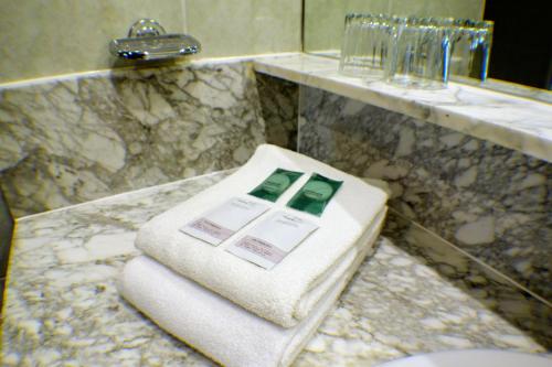 - Baño con una toalla en la encimera en Trípolis Toledo, en Toledo