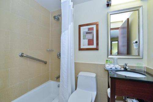 a bathroom with a tub and a toilet and a sink at Holiday Inn Express Manhattan Midtown West, an IHG Hotel in New York