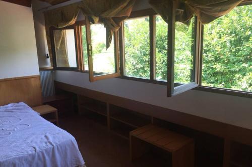 a bedroom with a bed and three windows at Casa Vacanze Almades in Almàdis