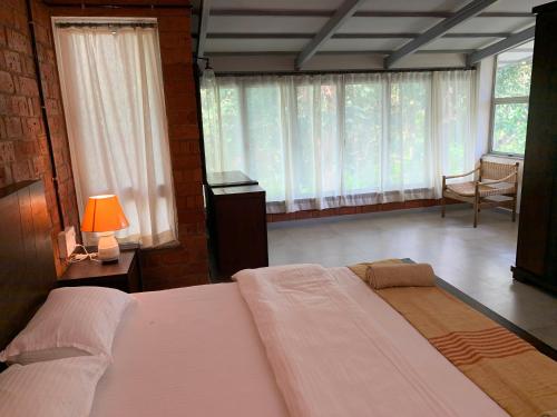 a bedroom with a large bed with a lamp and a chair at The Island Sanctuary - A Village Secret in Chorao