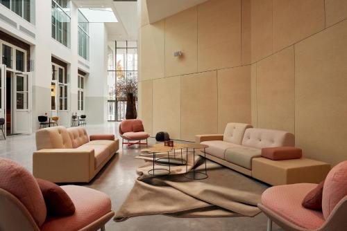 a lobby with couches and chairs and a table at Hotel Mariënhage in Eindhoven