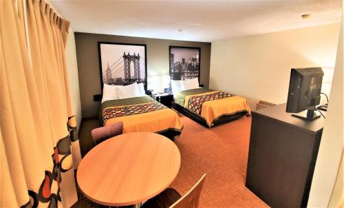a hotel room with two beds and a tv at Super 8 by Wyndham Monticello in Monticello