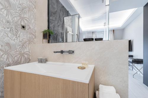 a bathroom with a sink and a mirror at Le Dortoir Boutique Suites in Nice