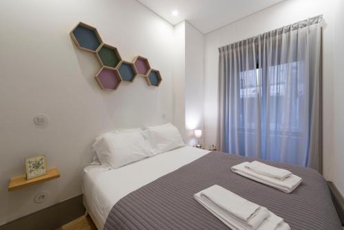een slaapkamer met een bed met twee handdoeken erop bij LovelyStay - Stylish Central Apartment by Bolhão Market in Porto