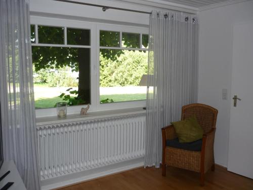 a room with a window with a chair and a cat sitting in it at Eggers - gemütliche Ferienwohnung im Erdgeschoss in Wallsbüll