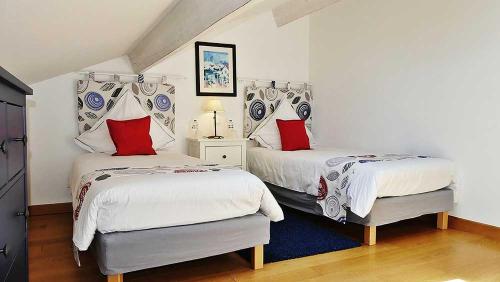 a bedroom with two beds with red pillows at Mas de Capelou in Avignon