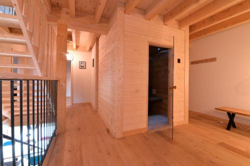 Habitación con pared de madera y puerta en Les Granges Modernes en Bruebach