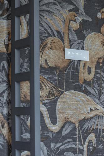 a curtain with a pattern of flamingos on a wall at Le Dortoir Boutique Suites in Nice