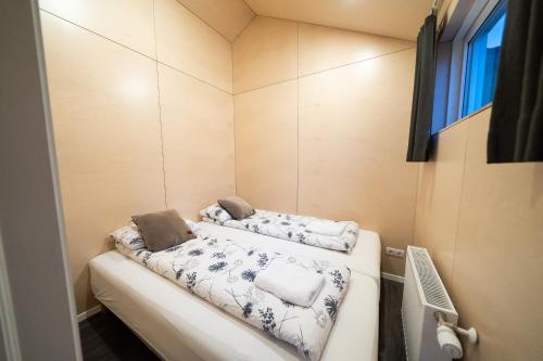 EyvindarhólarにあるWelcome Holiday Homeのベッド2台と窓が備わる小さな客室です。