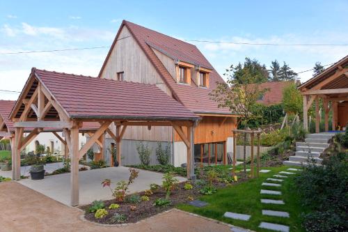 a barn style house with a wooden roof at Les Granges Modernes in Bruebach