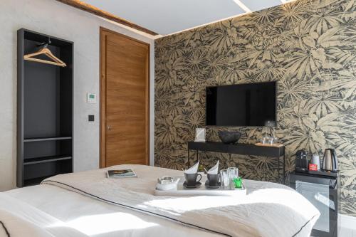 a bedroom with a bed and a tv on a wall at Le Dortoir Boutique Suites in Nice