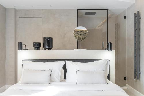 a bedroom with a large white bed with white pillows at Le Dortoir Boutique Suites in Nice