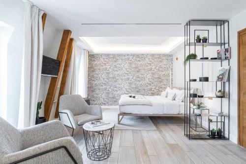 a living room with a bed and two chairs at Le Dortoir Boutique Suites in Nice