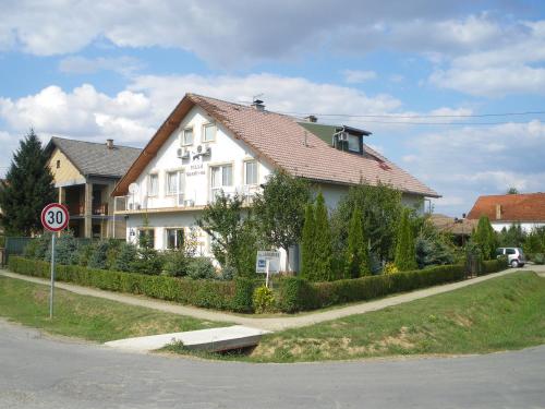une maison blanche sur le côté d'une rue dans l'établissement B&B Sandrina, à Bilje