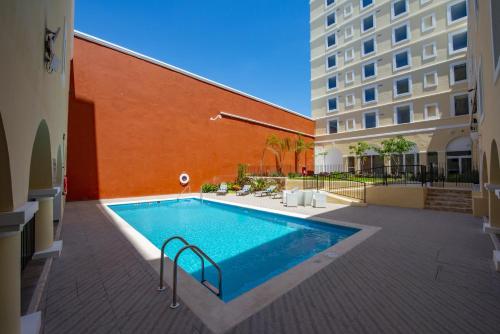 a swimming pool in front of a building at Holiday Inn Express Merida Centro by IHG in Mérida