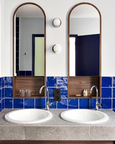 two sinks in a bathroom with two mirrors at New Hotel Le Quai - Vieux Port in Marseille