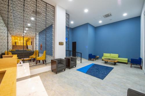 a waiting room with a blue wall and chairs at Holiday Inn Express Merida Centro by IHG in Mérida