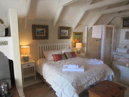 a bedroom with a bed with two towels on it at Marlyn and Dolfyn Self Catering in Paternoster
