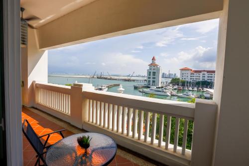 a balcony with a table and a view of the water at The Straits Quay Marina by Messina Clive in George Town