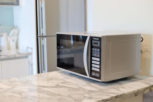 a microwave oven sitting on top of a counter at The Straits Quay Marina by Messina Clive in George Town