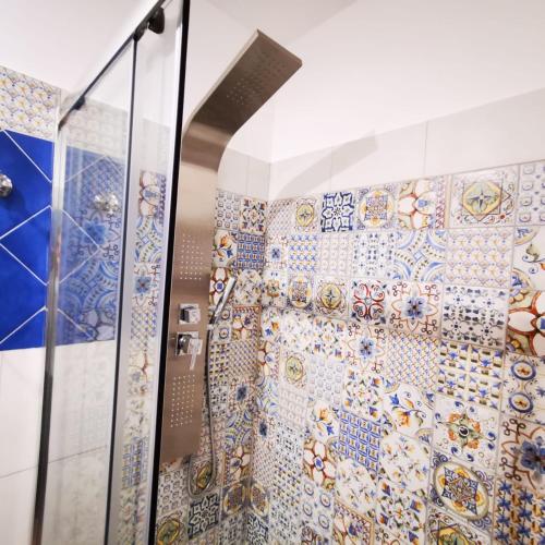 a bathroom with a shower with a mosaic tile wall at room n.22 suite & apartment in Taranto