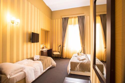 a hotel room with two beds and a window at Nice Rome Holiday in Rome