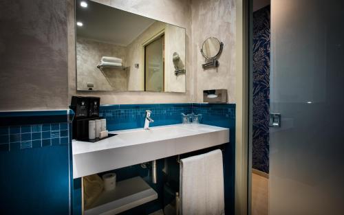 a bathroom with a white sink and a mirror at Grand Hotel Resort&SPA Ma&Ma - Adults Only in La Maddalena