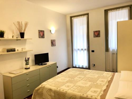 a bedroom with a bed and a desk with a television at La Terrazza del Centro in Bergamo