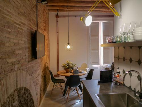 a kitchen with a brick wall and a table with chairs at Luxury Apartment Stancesvic in Vic