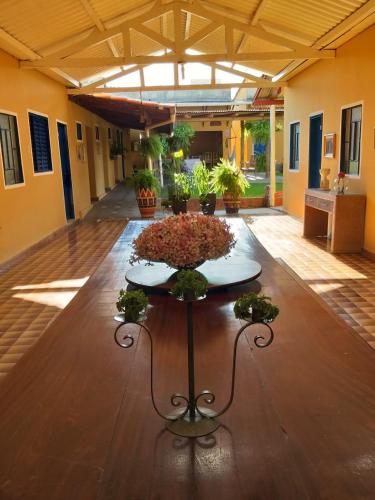 a table with flowers on it in a room at Pousada Dois Rios in Barra do Garças