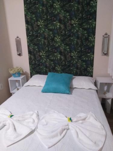 a bed with two white towels on top of it at Pousada Dois Rios in Barra do Garças