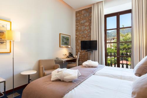 um quarto de hotel com duas camas e uma janela em Gran Hotel Soller em Sóller