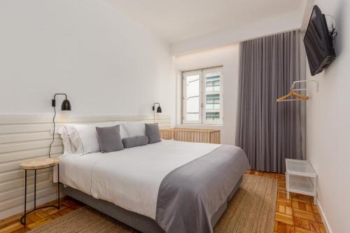 波多的住宿－波爾圖葡萄酒菲爾聯排公寓，卧室设有一张白色大床和一扇窗户。