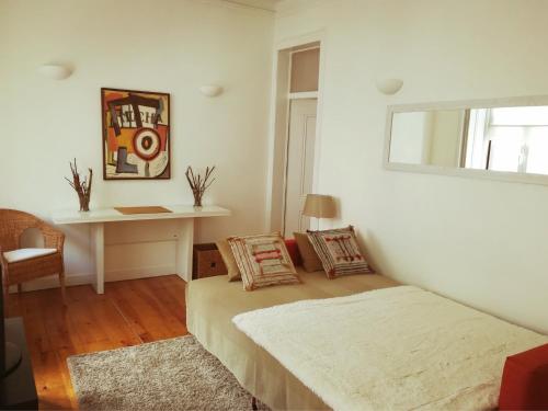 a white room with a bed and a desk at Lovely Apartment near Belém in Lisbon