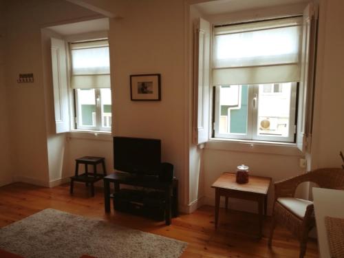 uma sala de estar com duas janelas e um sofá em Lovely Apartment near Belém em Lisboa