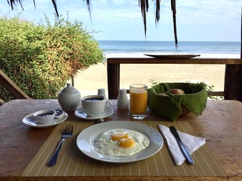 een bord eieren op een tafel met uitzicht op het strand bij Bungalows Las Balsas in Máncora
